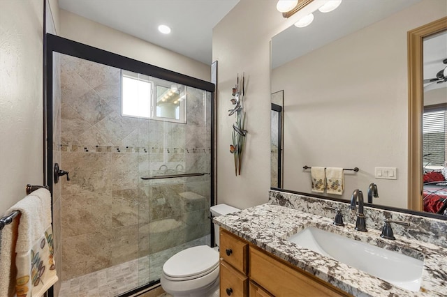 bathroom with vanity, a healthy amount of sunlight, toilet, and a shower with door