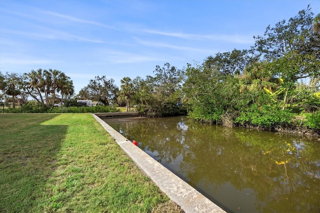 dock area featuring a lawn and a water view