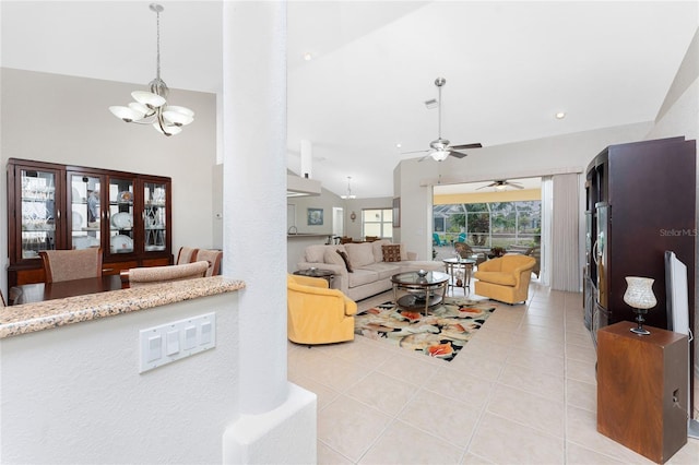 tiled living room featuring ceiling fan with notable chandelier and lofted ceiling