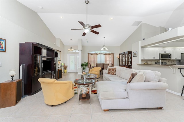 tiled living room featuring high vaulted ceiling and ceiling fan with notable chandelier