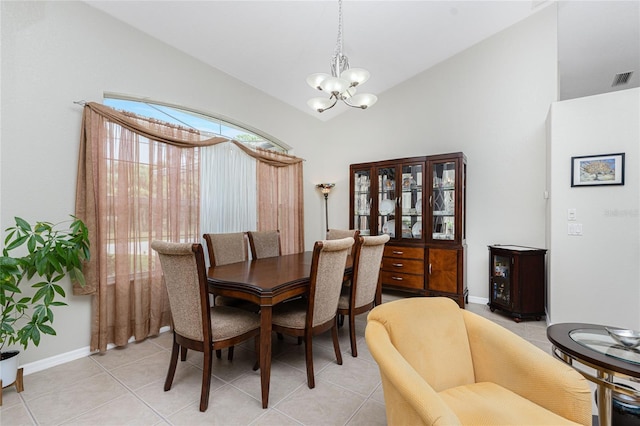 tiled dining area featuring an inviting chandelier and lofted ceiling