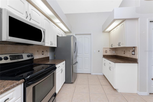 kitchen featuring tasteful backsplash, white cabinets, stainless steel appliances, and light tile patterned floors