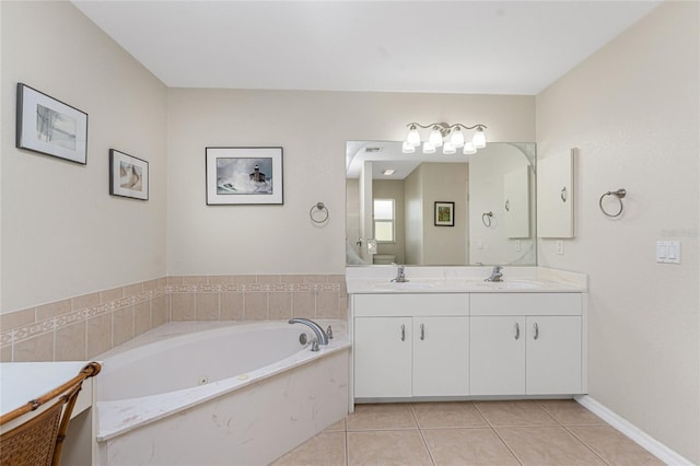 bathroom with tile patterned flooring, vanity, and a relaxing tiled tub