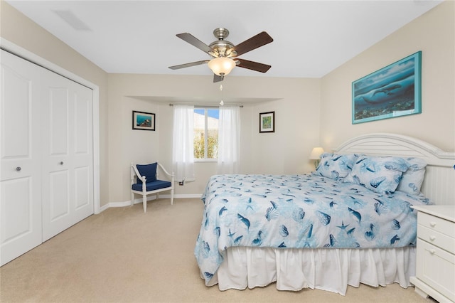 bedroom with ceiling fan, light colored carpet, and a closet