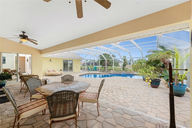 view of swimming pool with glass enclosure, a patio area, and ceiling fan