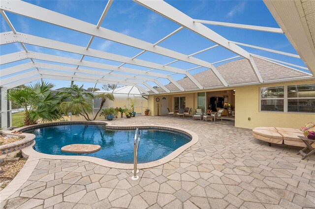 view of pool featuring glass enclosure and a patio