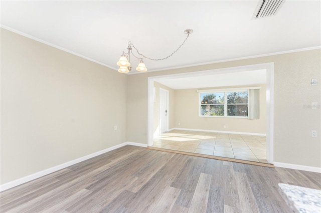 unfurnished room featuring an inviting chandelier, crown molding, and light wood-type flooring