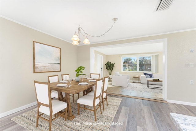 dining space featuring baseboards, light wood-style floors, and an inviting chandelier