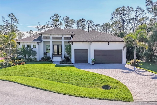 view of front of home with french doors, a garage, and a front lawn