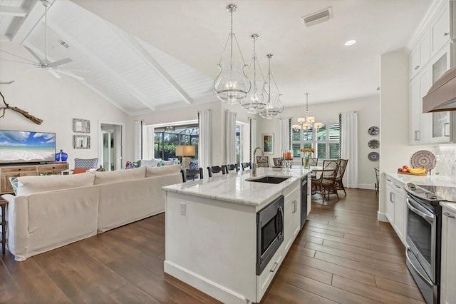 kitchen featuring light stone countertops, appliances with stainless steel finishes, sink, a center island with sink, and white cabinets