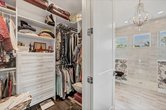 spacious closet with an inviting chandelier