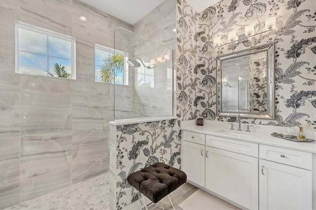 bathroom featuring a tile shower and vanity