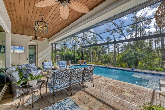 view of swimming pool featuring outdoor lounge area, glass enclosure, and a patio area