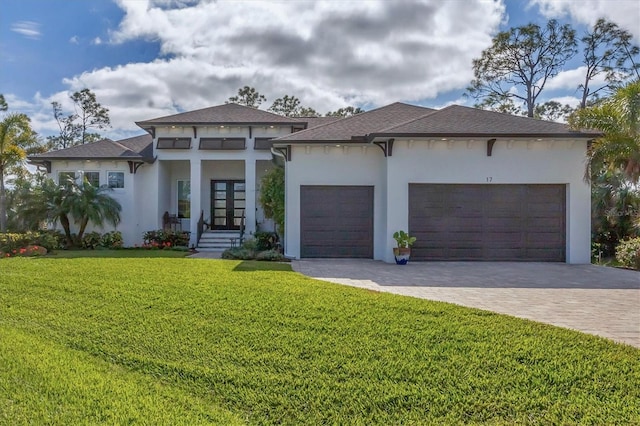 view of front of home featuring a front yard, french doors, and a garage