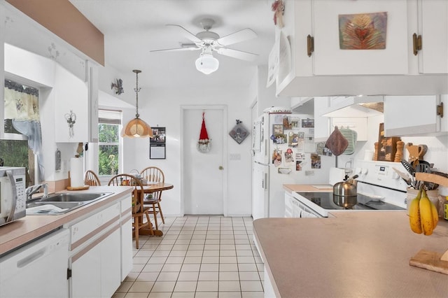 kitchen with sink, light tile patterned floors, white appliances, decorative light fixtures, and white cabinets