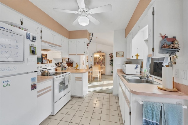 kitchen featuring white appliances, sink, hanging light fixtures, light tile patterned flooring, and white cabinetry