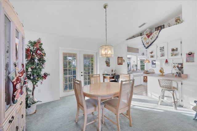 carpeted dining space featuring french doors