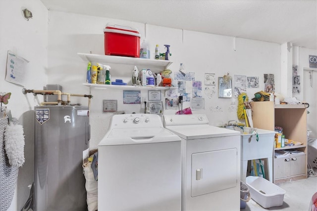 laundry room with washing machine and clothes dryer and water heater