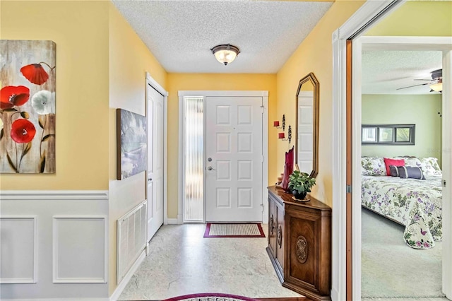 entrance foyer featuring ceiling fan and a textured ceiling