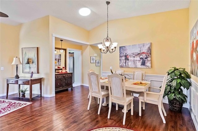 dining room with dark hardwood / wood-style flooring, vaulted ceiling, and a notable chandelier