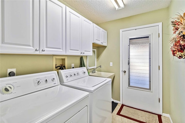 washroom with sink, cabinets, a textured ceiling, and washing machine and clothes dryer