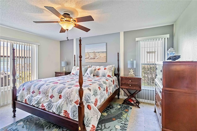 bedroom with ceiling fan, a textured ceiling, and multiple windows