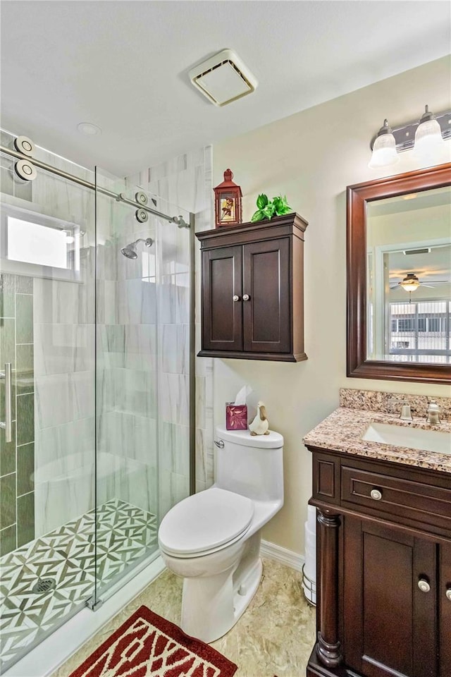 bathroom with vanity, toilet, an enclosed shower, and ceiling fan