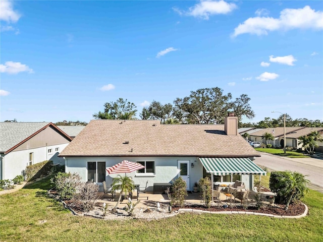 rear view of house with a lawn and a patio area