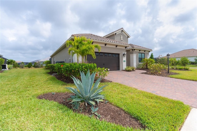 mediterranean / spanish home featuring a front yard and a garage