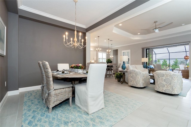 tiled dining space featuring ceiling fan with notable chandelier, crown molding, and a tray ceiling