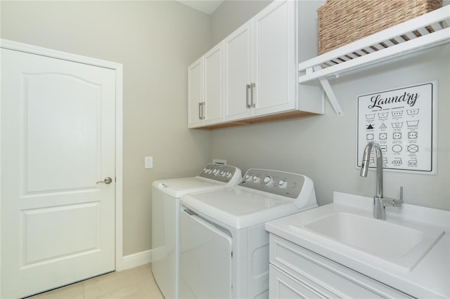 washroom with washer and clothes dryer, cabinets, light tile patterned floors, and sink