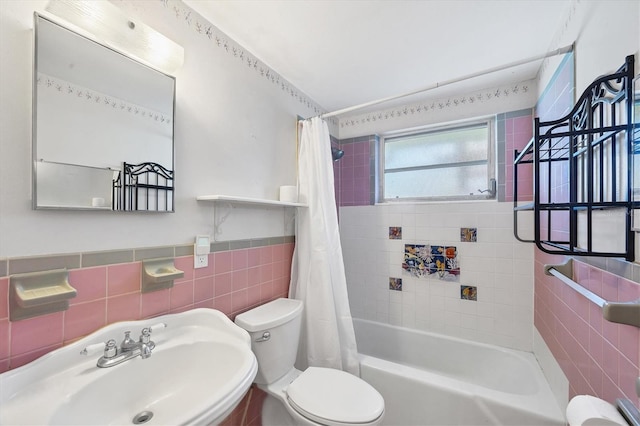 full bathroom featuring sink, shower / bathtub combination with curtain, tile walls, and toilet