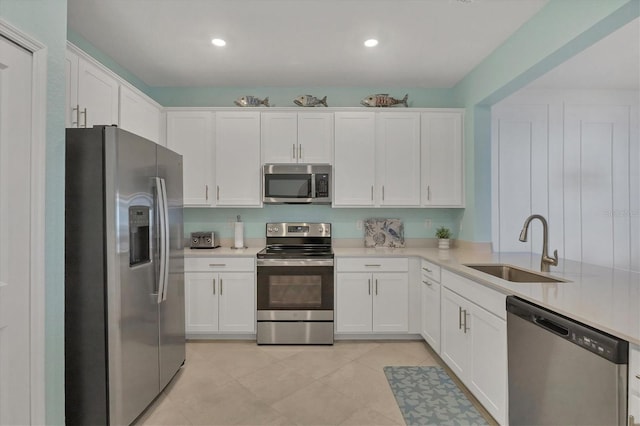 kitchen featuring a sink, white cabinetry, stainless steel appliances, and light countertops