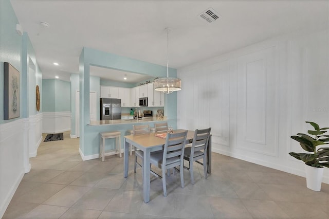 dining room with recessed lighting, light tile patterned flooring, visible vents, and a decorative wall