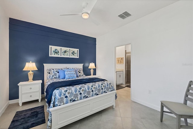 bedroom with ensuite bathroom, light tile patterned flooring, visible vents, and baseboards