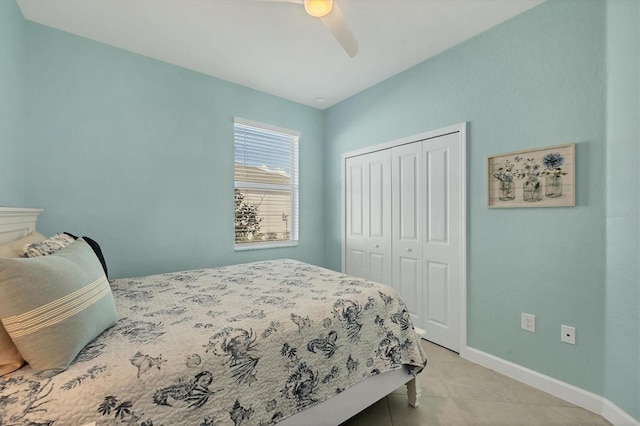 bedroom featuring a closet, light tile patterned flooring, ceiling fan, and baseboards