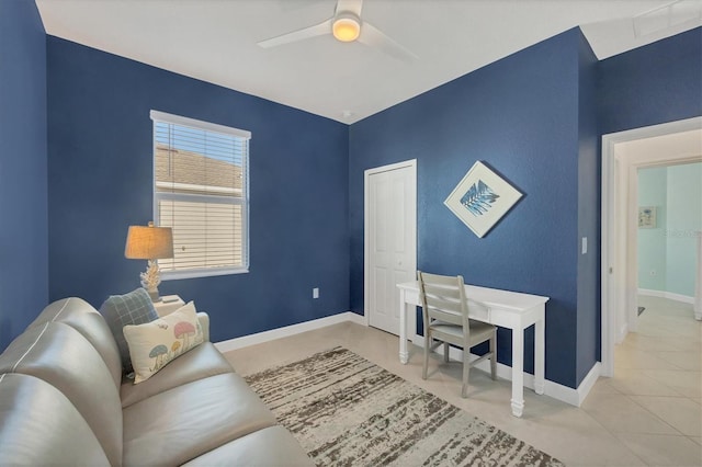 home office featuring light tile patterned floors, ceiling fan, and baseboards