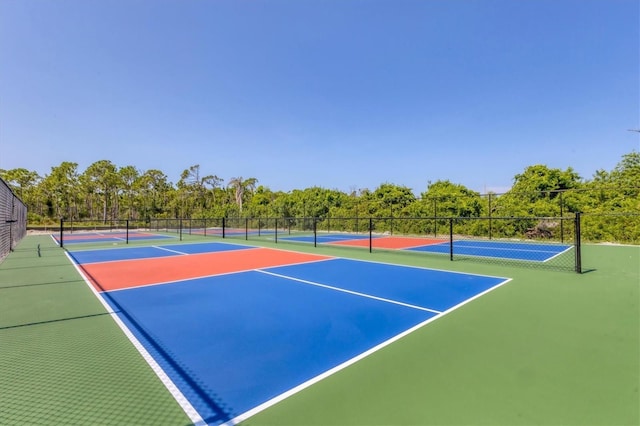 view of tennis court featuring community basketball court and fence