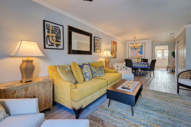 living room featuring dark hardwood / wood-style floors, crown molding, and a notable chandelier