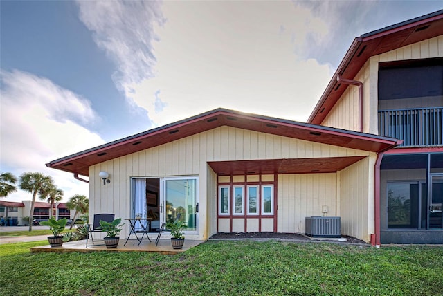 back of property featuring a lawn, a patio, and central AC