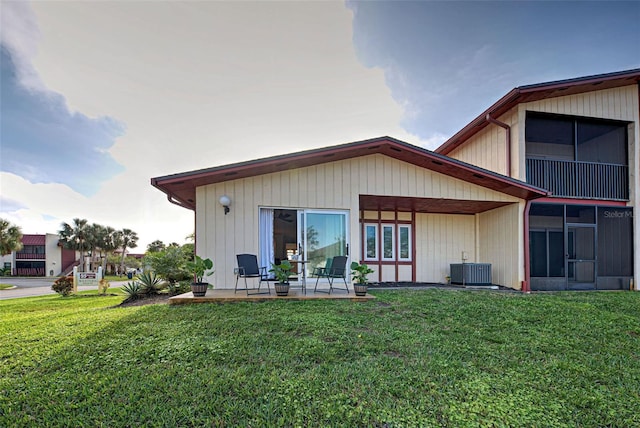 rear view of property featuring a sunroom, a yard, and a patio