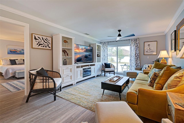 living room featuring hardwood / wood-style flooring, ceiling fan, and crown molding