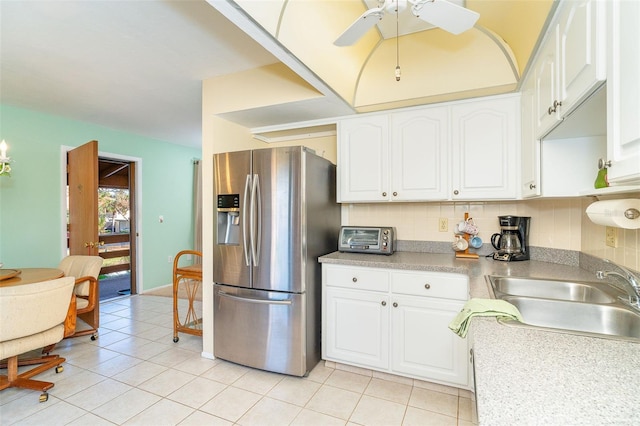 kitchen featuring stainless steel fridge, sink, white cabinets, and ceiling fan