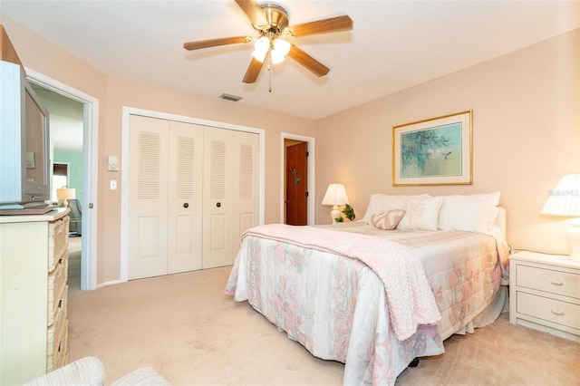 bedroom featuring light carpet, a closet, and ceiling fan