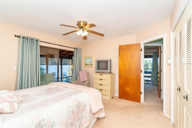 carpeted bedroom with access to outside, ceiling fan, and a closet