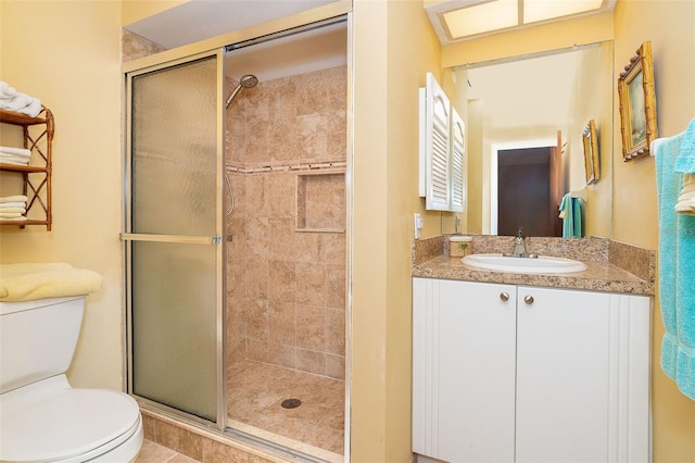 bathroom featuring tile patterned floors, vanity, toilet, and a shower with shower door