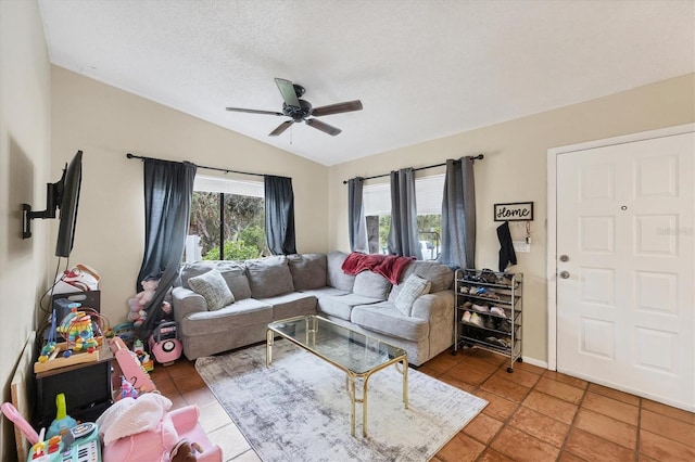 living room with tile patterned floors, ceiling fan, lofted ceiling, and a textured ceiling