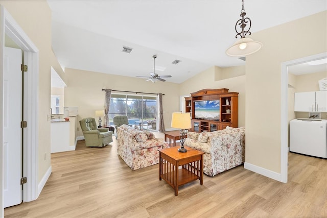 living room featuring washer / dryer, vaulted ceiling, light hardwood / wood-style flooring, and ceiling fan