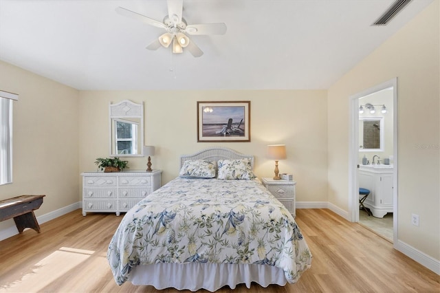 bedroom with ceiling fan, light hardwood / wood-style floors, sink, and connected bathroom