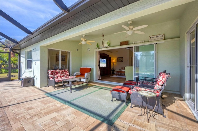 view of patio / terrace featuring ceiling fan and glass enclosure